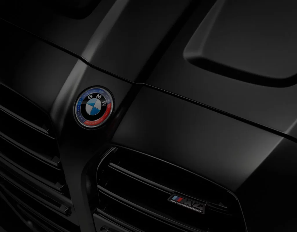 Close-up of a sleek black BMW with a focus on the hood and emblem, featuring the BMW logo and M4 Competition badge. The image emphasizes luxury and style, ideal for showcasing BMW Drivers Club's website design pitch.