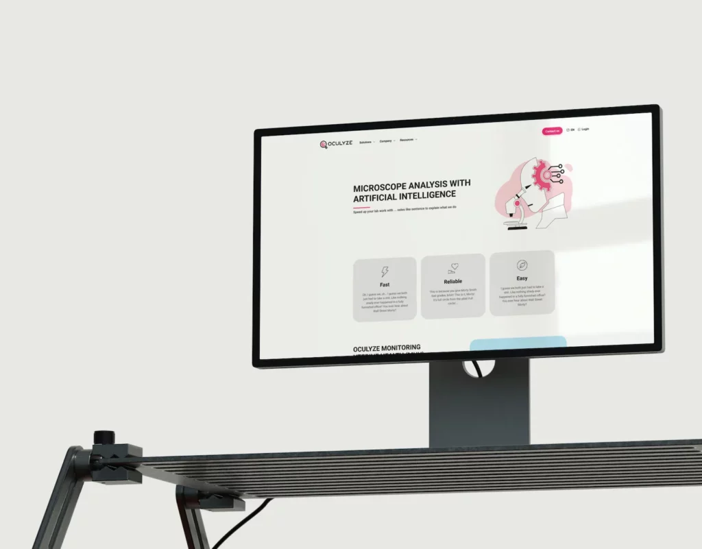 A computer monitor displays the Oculyze website design, featuring the headline "Microscope Analysis with Artificial Intelligence" and an illustration of a head with gears looking into a microscope. Below, there are sections labeled "Fast," "Reliable," and "Easy." The screen is positioned on a modern, adjustable desk stand.
