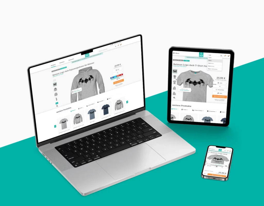 The image showcases a responsive design of the Spreadshirt unified marketplace on a laptop, tablet, and smartphone. Each device displays the same product page featuring a Batman logo T-shirt for purchase. The design adapts seamlessly to different screen sizes, emphasizing user-friendly navigation and consistency across platforms.